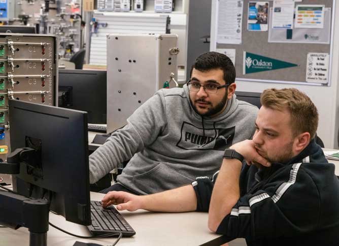 Two students working in the manufacturing lab at Oakton College.