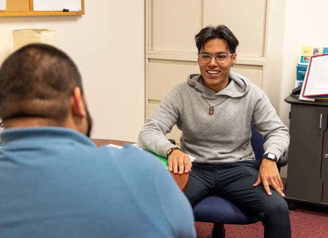 First generation student sitting at a table with advisor.