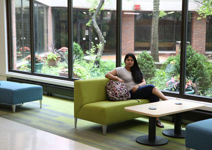 Young woman sitting on bench packs up backpack