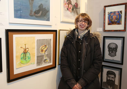 Student standing in front of art display.